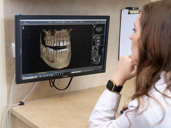 Dentist looking at scan of teeth