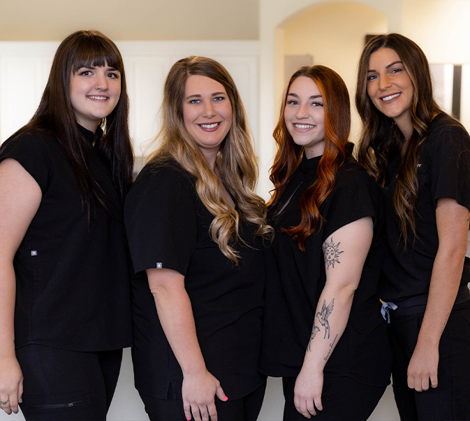 Dental team members standing in row and smiling