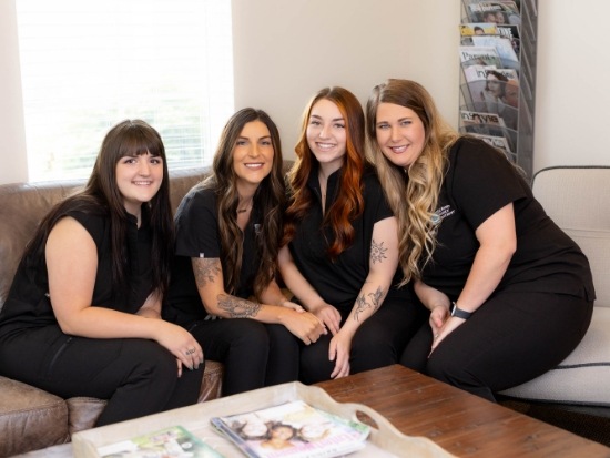 Dental team members sitting down and smiling