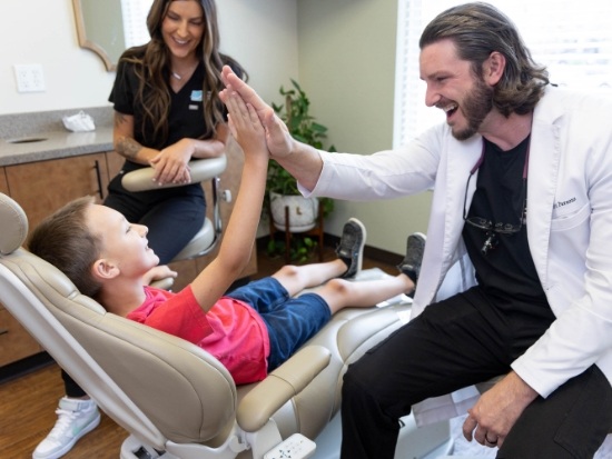 Dr Parsons giving young dental patient a high five