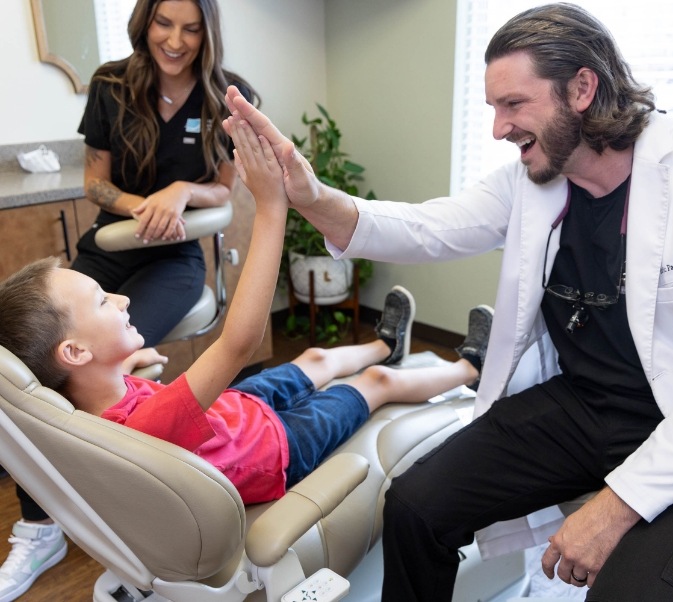 Childrens dentist in El Reno giving young patient a high five