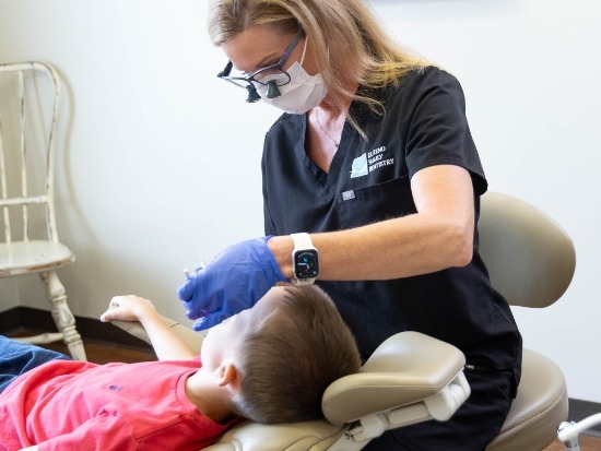 Female dentist examining little boys teeth