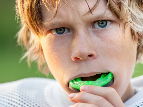 Young boy putting in an athletic mouthguard