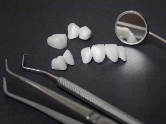 Dental restorations and dental instruments on black surface