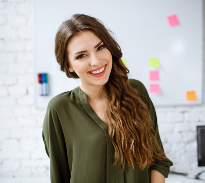 Woman in green shirt standing and smiling