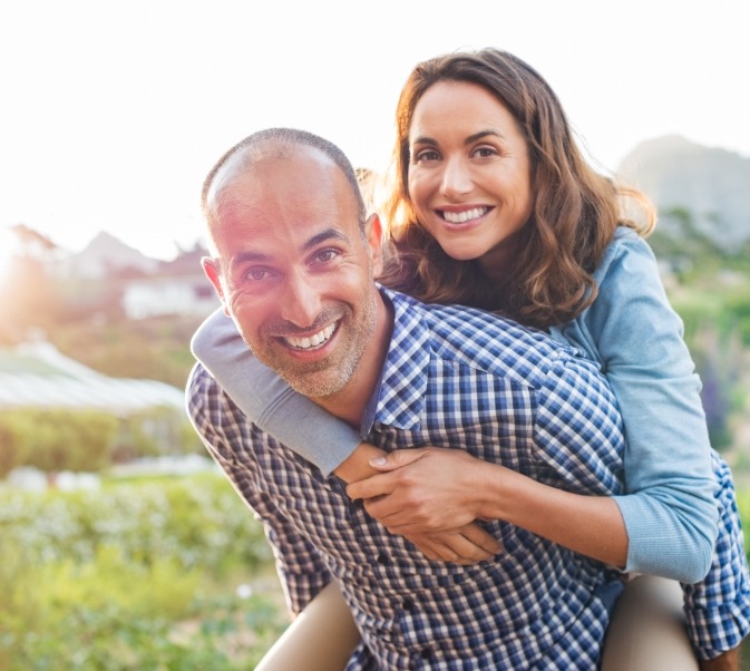 Man giving a woman a piggyback ride outdoors