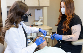 Two female dentists working on patients mouth