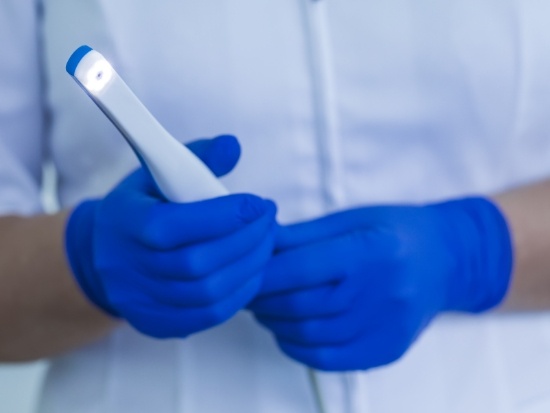 Gloved hands holding an intraoral camera