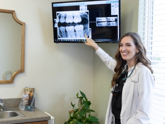 Female dentist pointing to a dental x ray