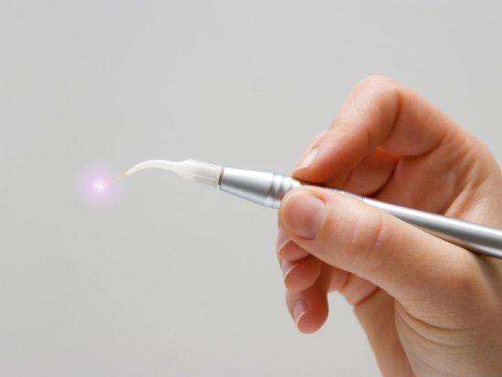 Hand holding a soft tissue dental laser