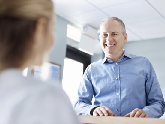 Patient talking to someone at front desk