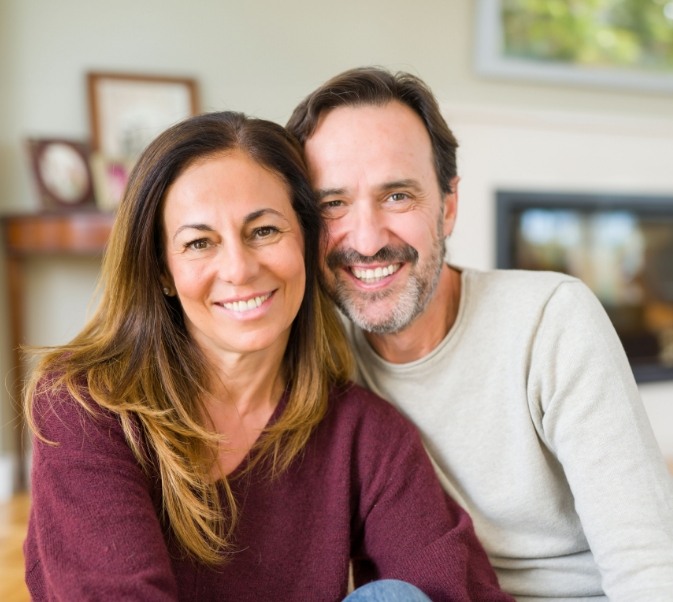 Man and woman leaning against each other and smiling