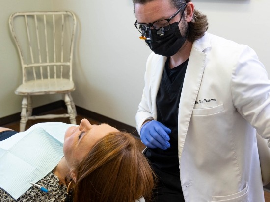 Dentist looking down at smiling dental patient