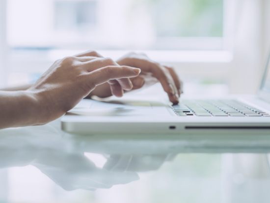 Hands typing keyboard on laptop