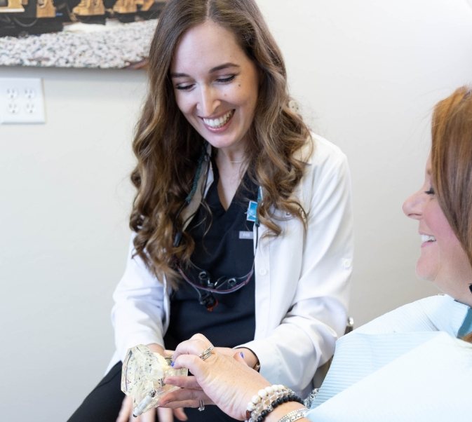 Dentist letting patient touch a dental model