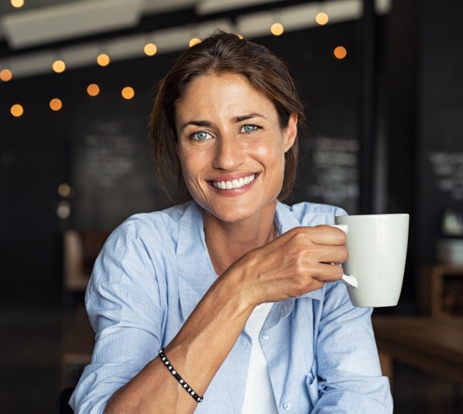 Woman holding a coffee cup and smiling