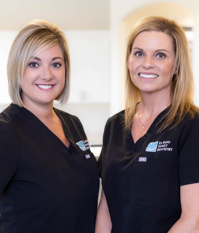 Two blonde dental team member smiling