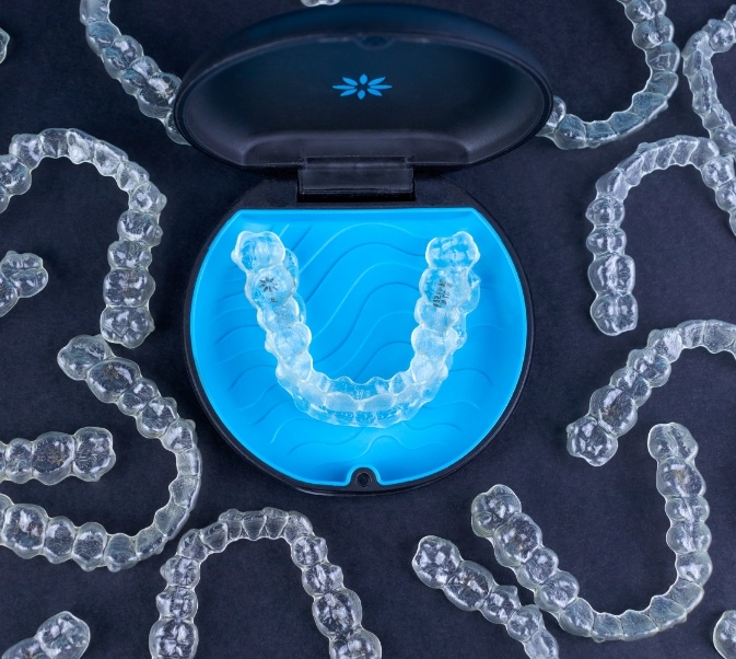 Clear aligner in case surrounded by many clear aligners for Invisalign in El Reno