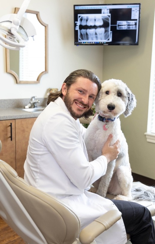 Dr Parsons smiling and hugging a dog