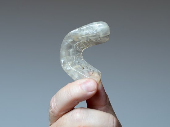 Hand holding a nightguard for bruxism