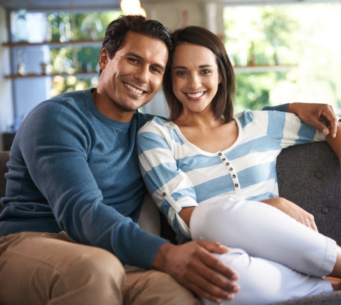 Man and woman sitting on couch smiling