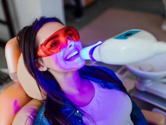 Female dental patient receiving in office teeth whitening