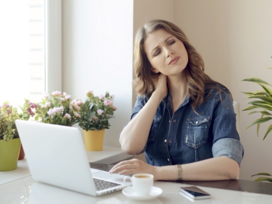 Woman sitting at table with jaw pain