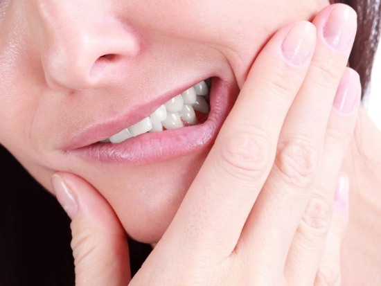 Close up of woman rubbing jaw in pain