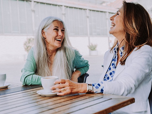 Smiling middle-aged woman having coffee 